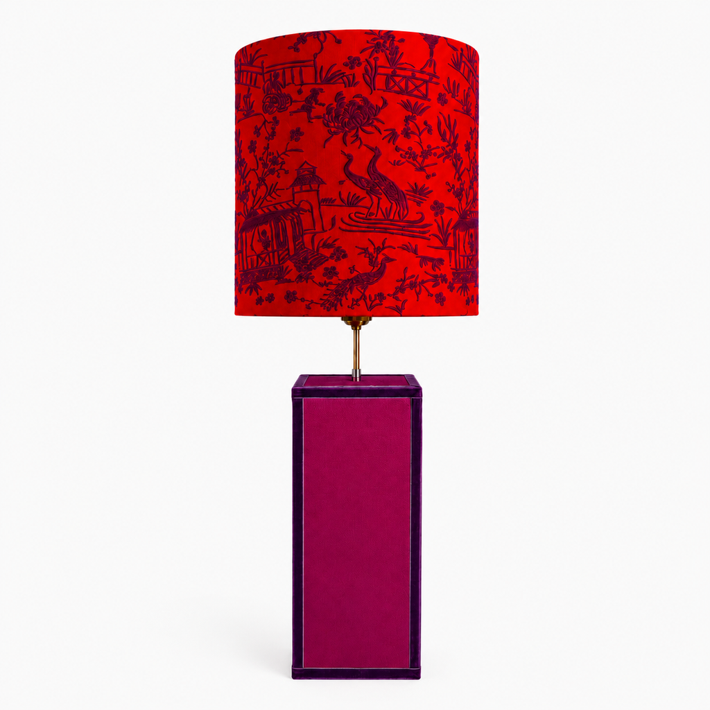 Lámpara de mesa con pantalla de bordado oriental y base artesanal, integrada en un salón elegante de estilo mediterráneo y atemporal.